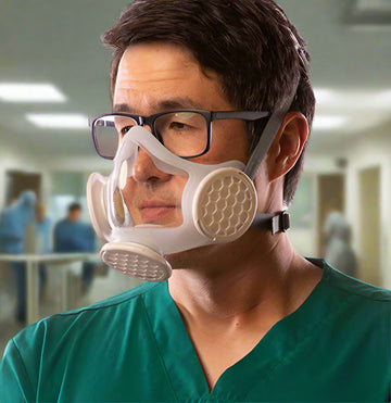 Asian man with glasses dressed in surgical shirt and wearing OmniMask.