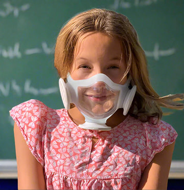 Happy young girl wearing OmniMask and smiling at the camera.